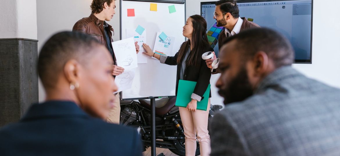woman in black blazer holding green folder presenting a business proposal